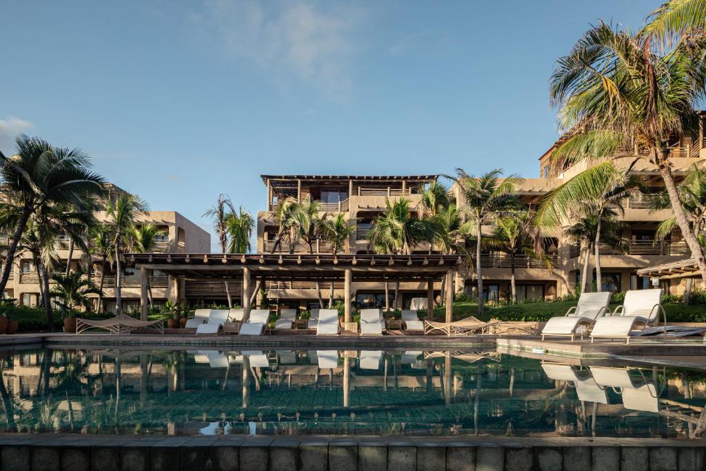 a resort with a swimming pool and palm trees at Aqua de Mar Condo Hotel in Icaraí