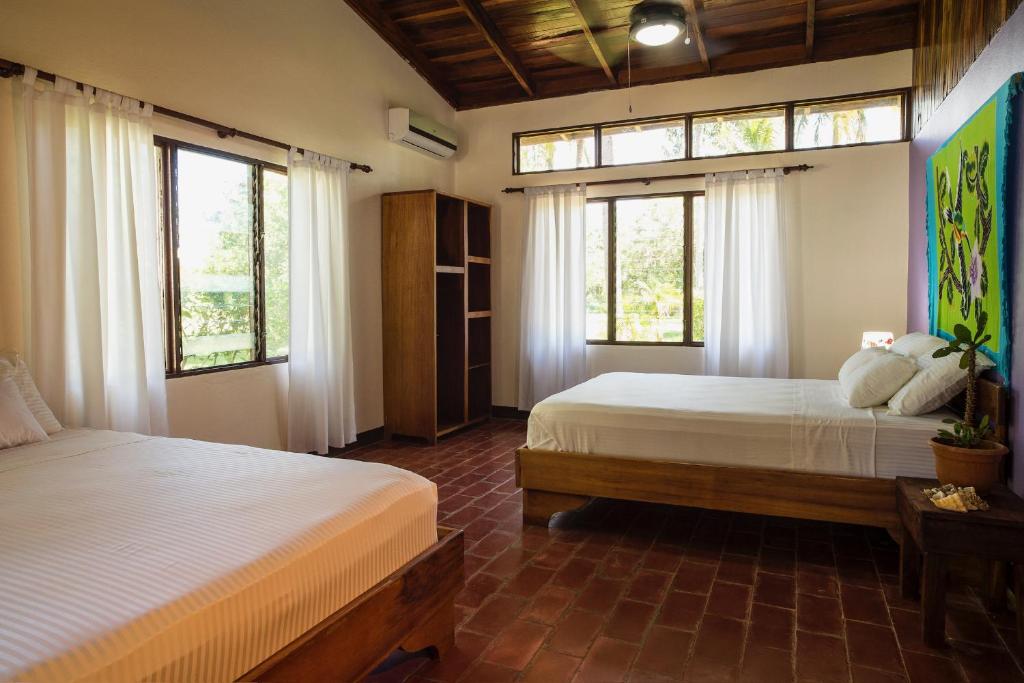 a bedroom with two beds and two windows at Tides Oceanfront Resort in Santa Cruz