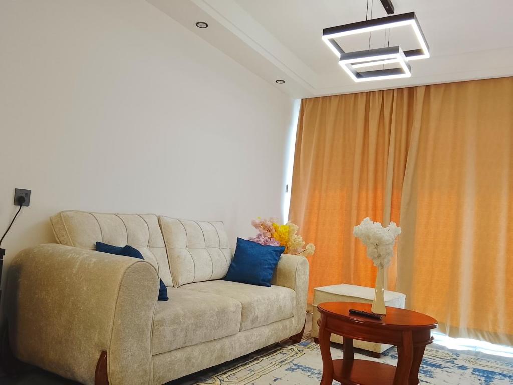 a living room with a couch and a table at Askarium Cozy Haven in Nairobi