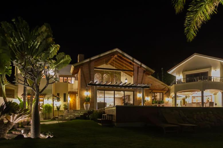 uma casa à noite com uma palmeira no quintal em Hotel Lindo Ajijic Bed & Breakfast em Ajijic