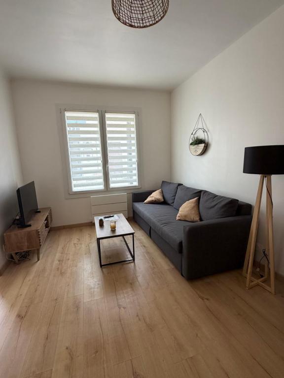 a living room with a couch and a table at JMAM Urban Suite T2 Climatisé en centre ville proche plage in Fos-sur-Mer