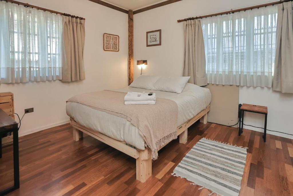 ein Schlafzimmer mit einem Bett, auf dem eine Handtasche liegt in der Unterkunft Casa Vigas, Ex-Rustika Hotel in Viña del Mar