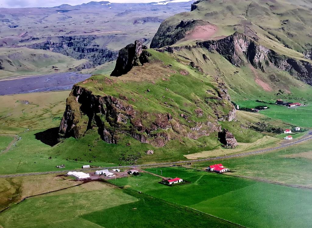 an aerial view of a mountain with a green field at Hrutafell Guesthouse in Hvolsvöllur