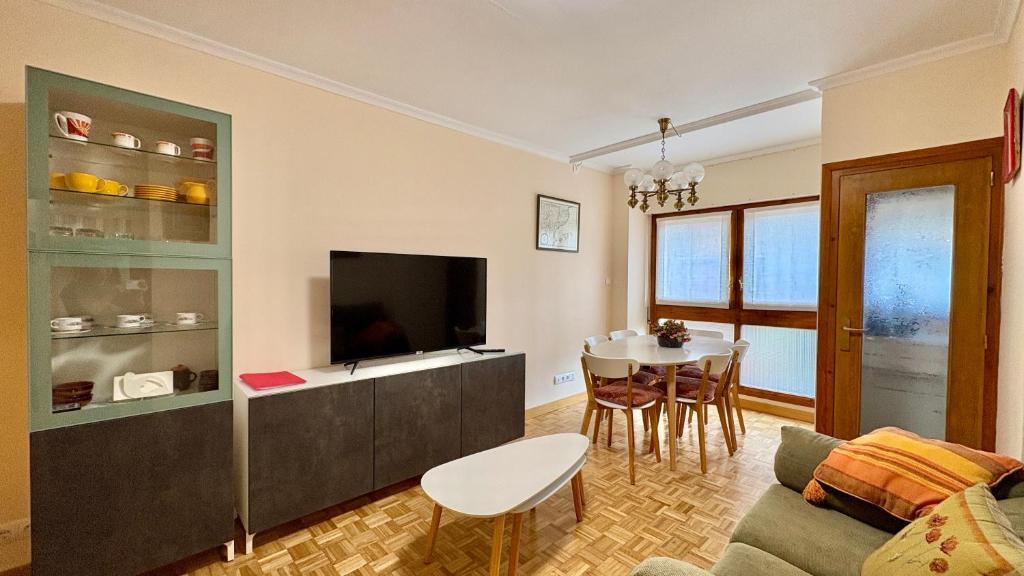 a living room with a couch and a tv and a table at Jaca Centrum in Jaca