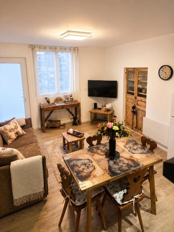a living room with a table and a couch at La Marmotte appartement cosy centre Briancon proche Prorel in Briançon
