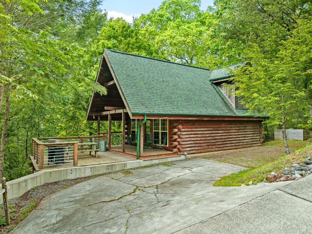 a log cabin in the woods with a driveway at Serenity in Townsend