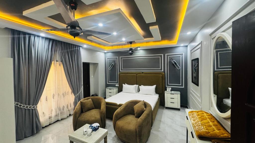 a hotel room with a bed and two chairs at Seaview lodge Executive in Karachi