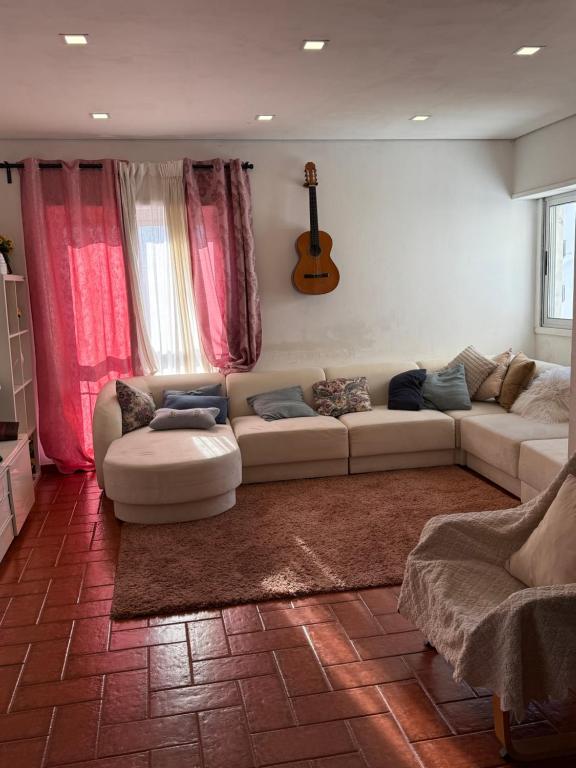 a living room with a couch and a guitar at The room in Odivelas