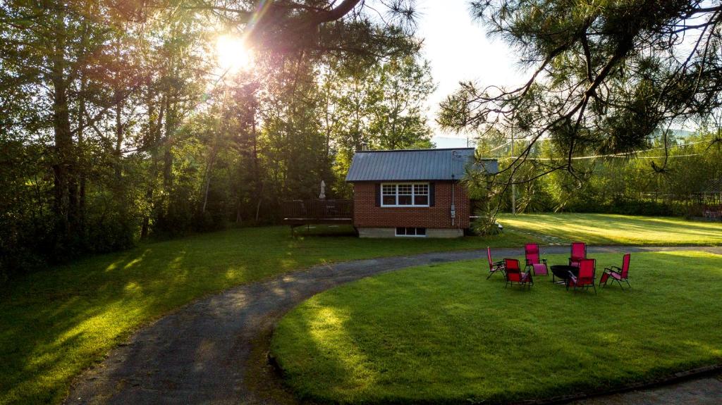 a group of red chairs in front of a cabin at Chalet Le RV 3 in Notre-Dame-Des-Bois