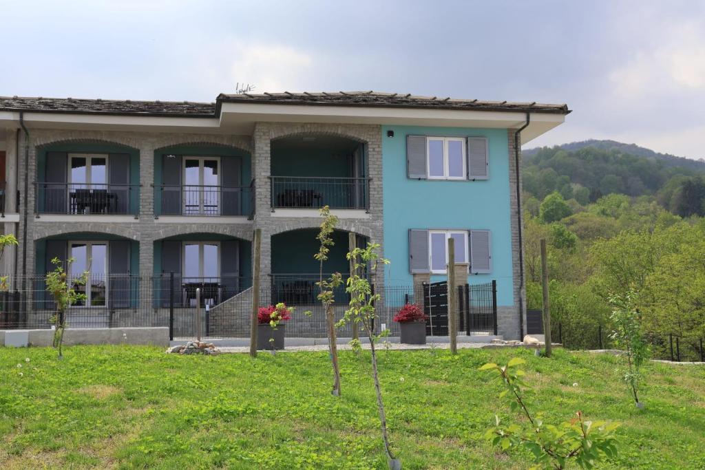 a blue house with a hill in the background at Casa Piutin, appartamento Bucaneve in Bagnolo Piemonte