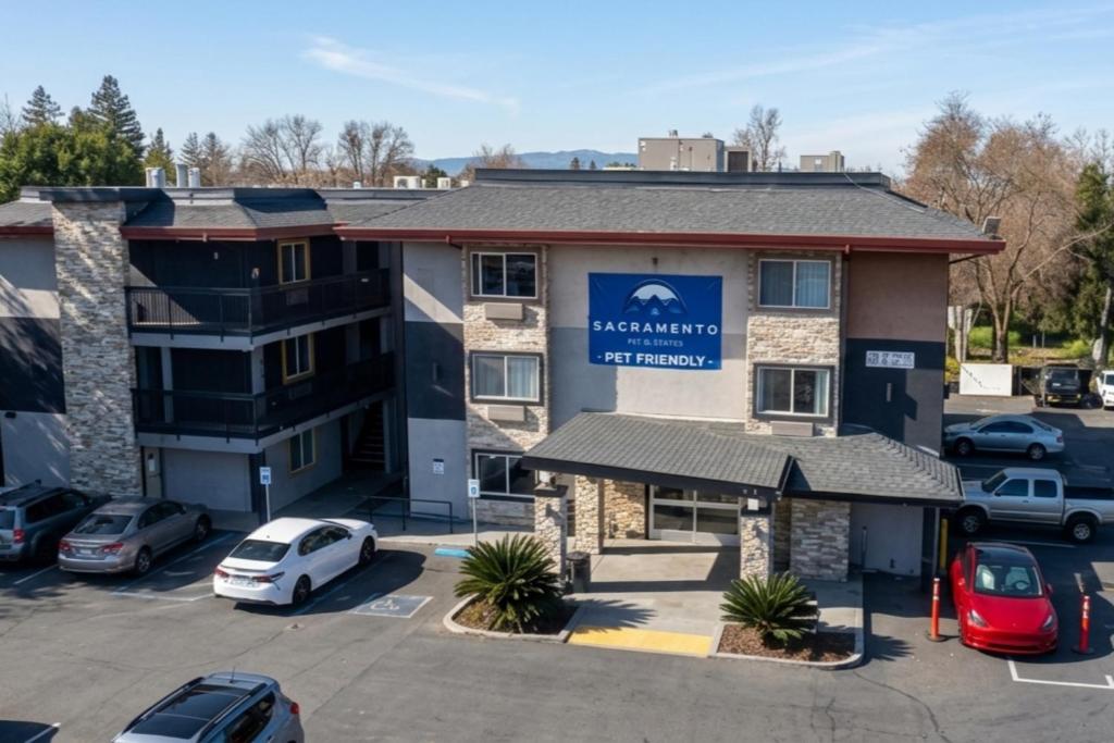 a hotel with cars parked in a parking lot at Sacramento Inn & Suites Cal Expo I-80 in Sacramento