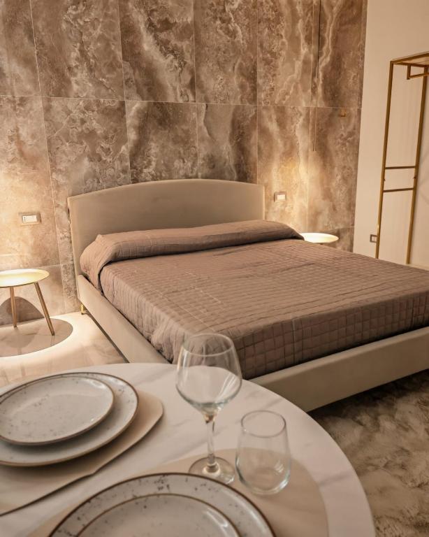 a bedroom with a bed and a table with plates and glasses at Suite Crystal Home with Jacuzzi in Trapani