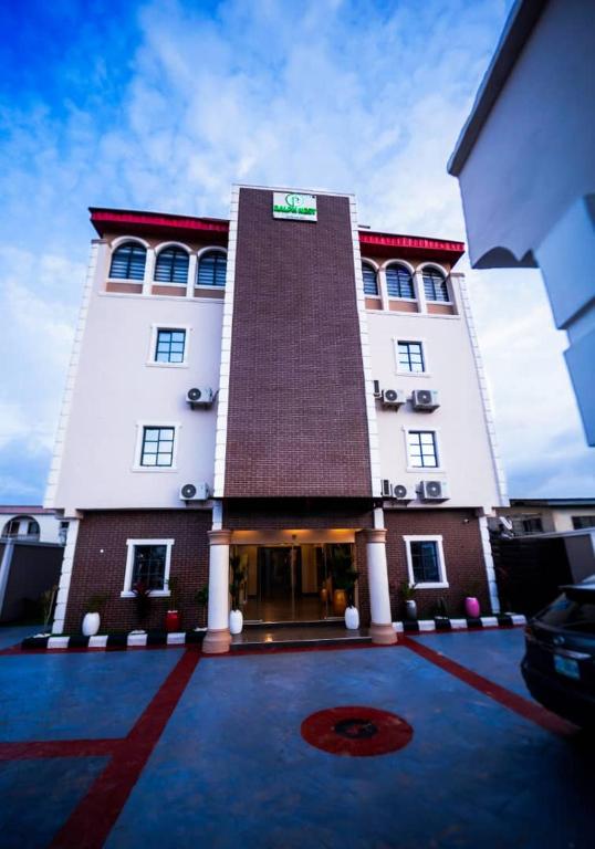 a large white building with a red roof at Ralphnest Suite & Lounge Limited in Otta