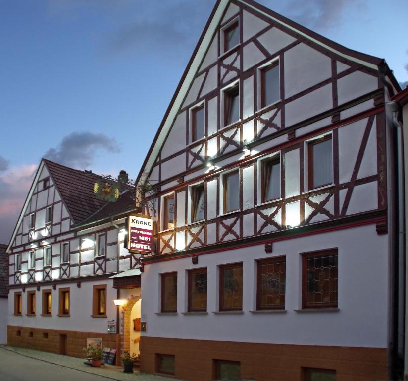 ein weißes Gebäude mit einer schwarz-weißen Fassade in der Unterkunft Hotel Krone in Tauberrettersheim