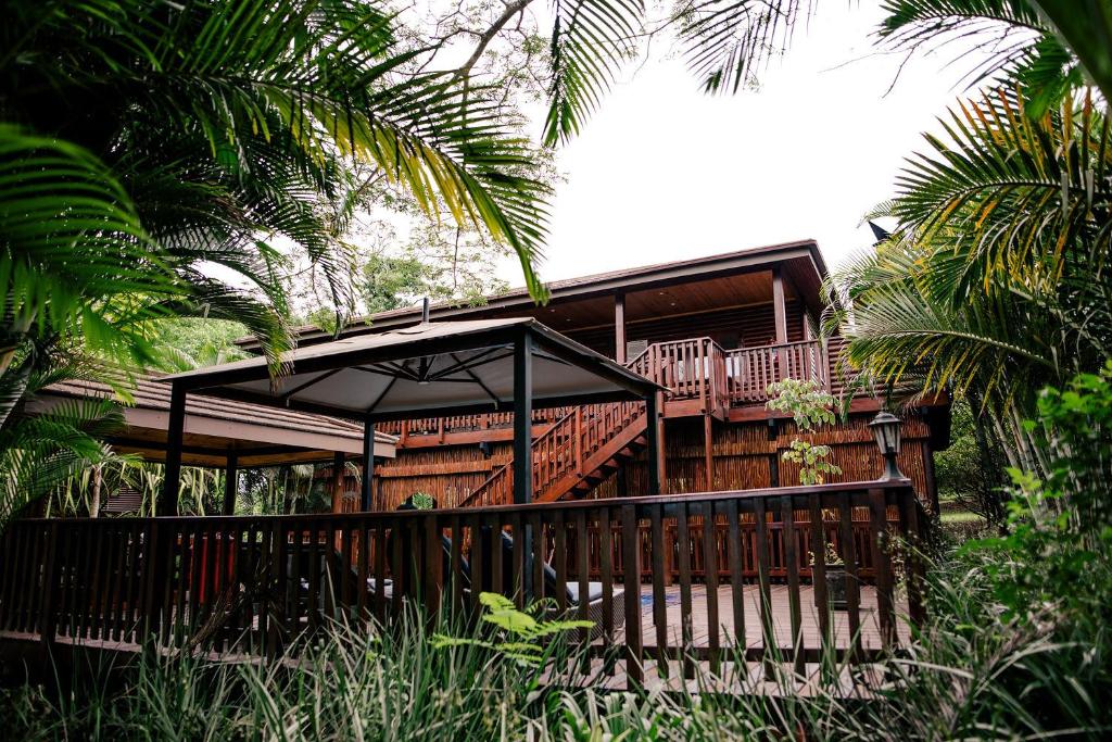 a wooden house with a deck and a porch at Monzi Safari Lodge in Monzi