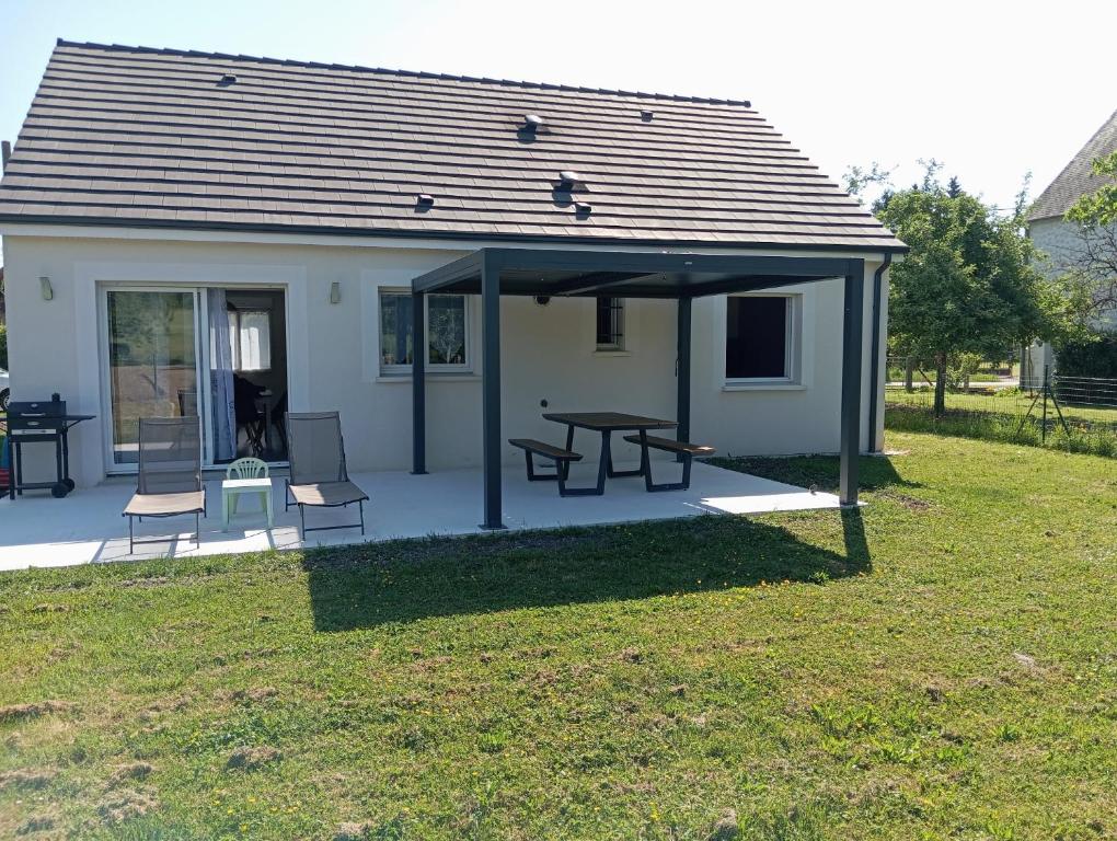 a pavilion with a picnic table and chairs in a yard at Loire et Vignes in Saint-Bouize