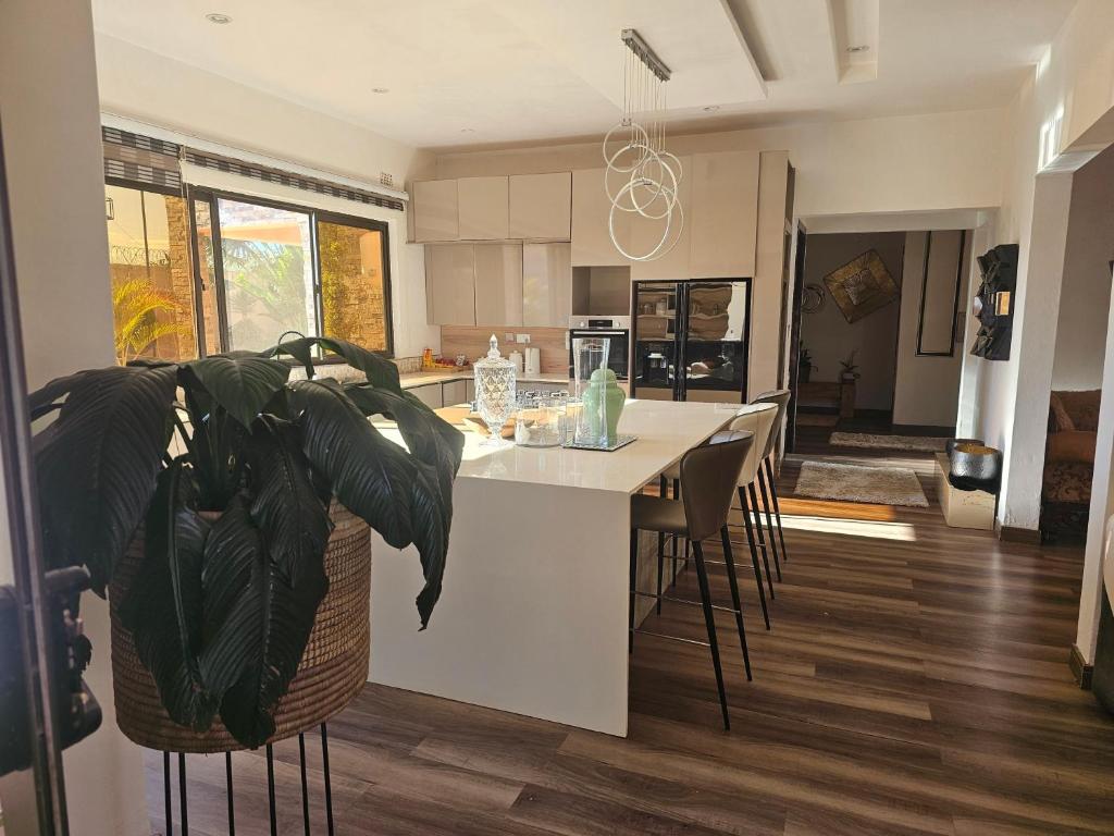 a kitchen with a table and chairs and a plant at Luxe Apartments in Lusaka