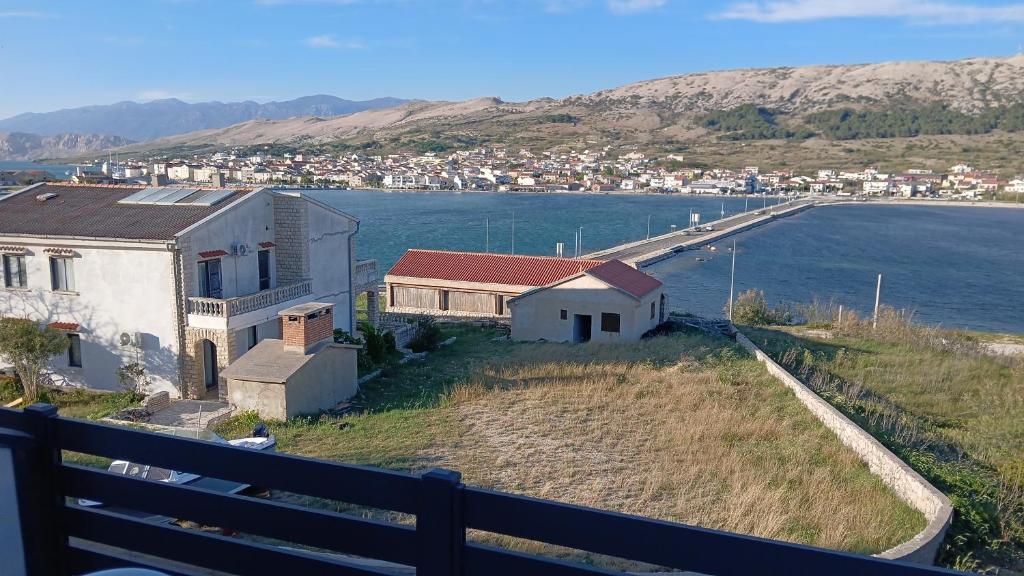 a house on a hill next to a body of water at Apartments Verica in Pag
