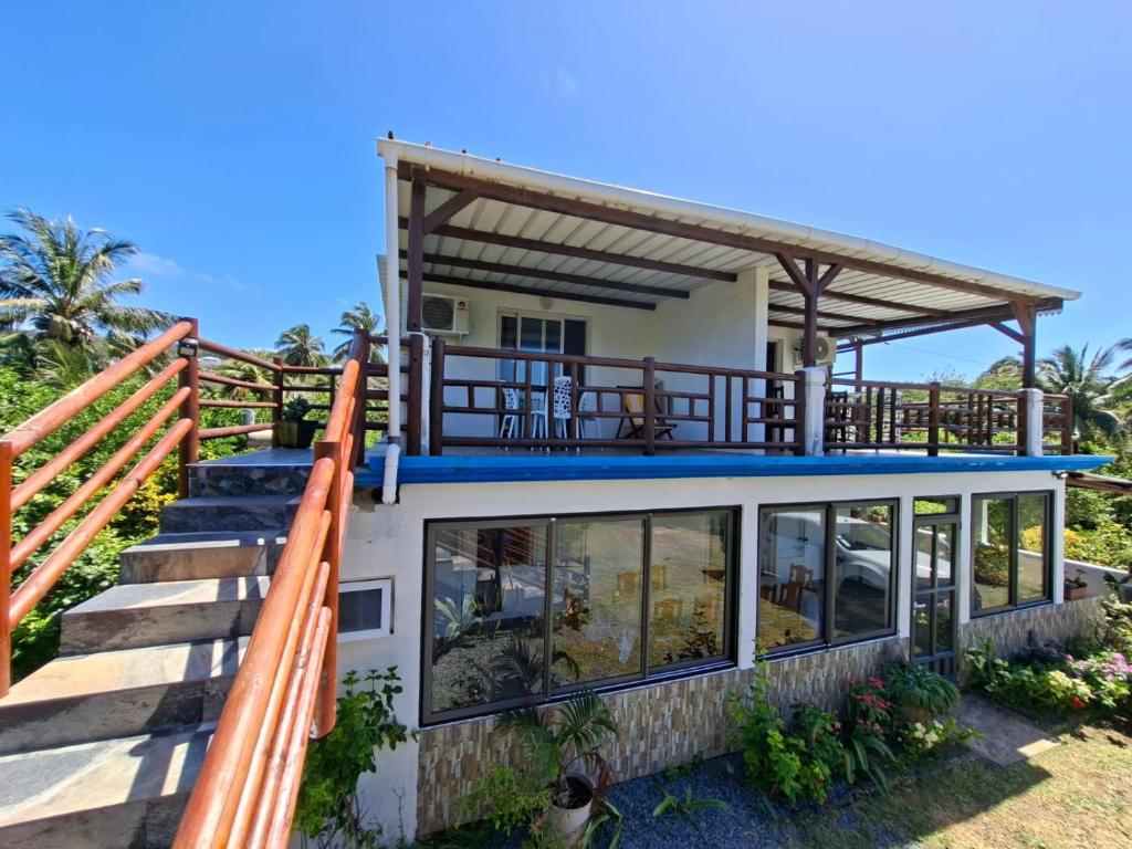 a house on the beach with a balcony at Poisson d'Or Guest House in Port Mathurin