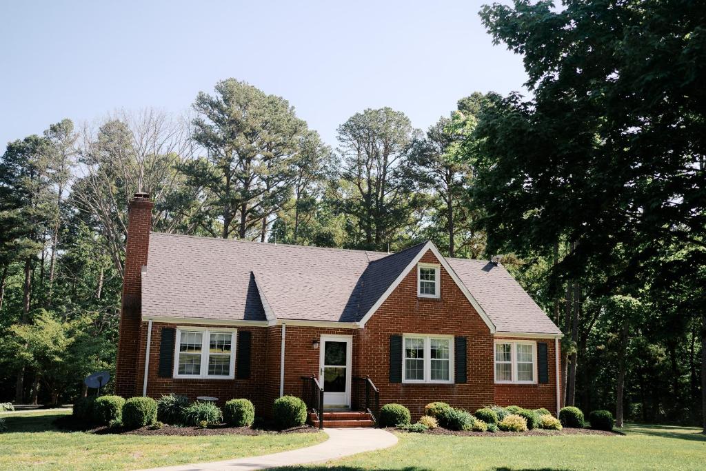 a red brick house with a black roof at Pine Creek Farm in Burkeville