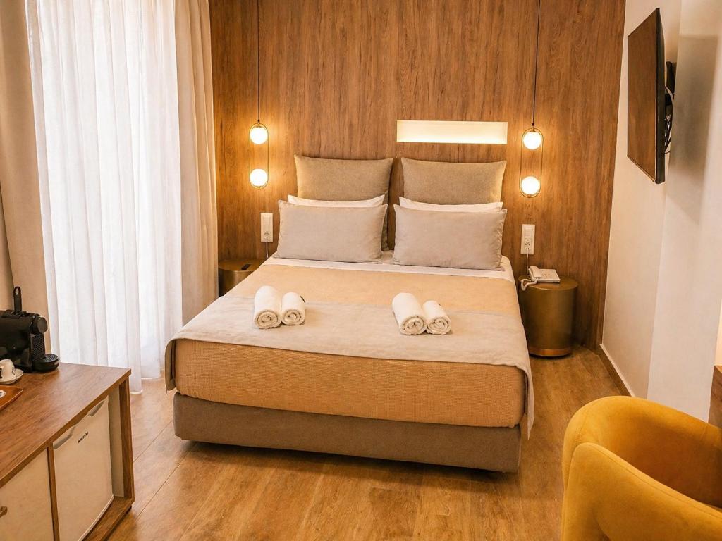 a bedroom with a bed with two towels on it at Morfeas City Hotel in Rhodes Town