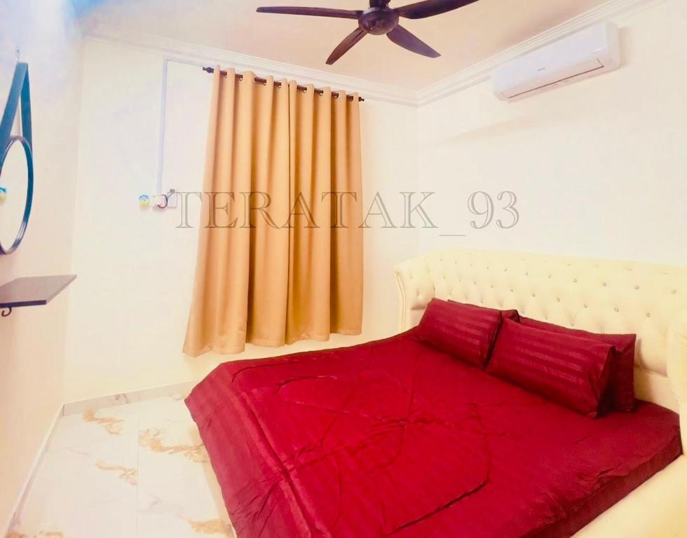 a bedroom with a red bed with a ceiling fan at Teratak 93 in Karak
