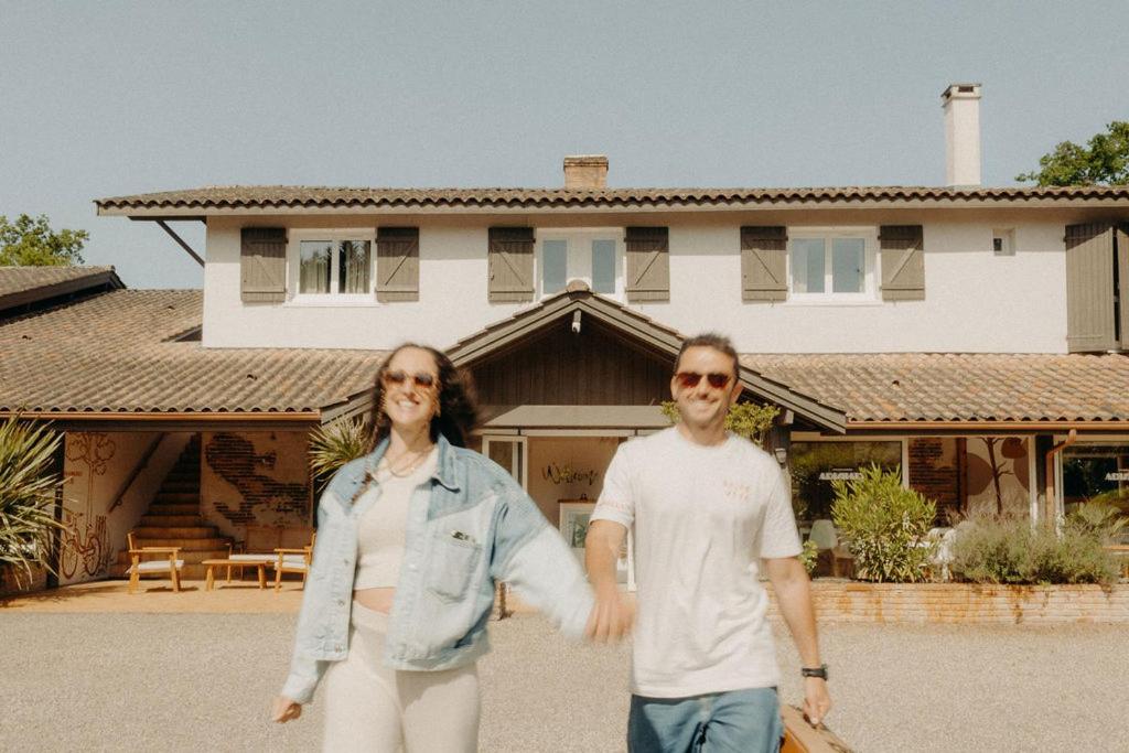 a man and a woman standing in front of a house at Adishatz Motel in Biscarrosse