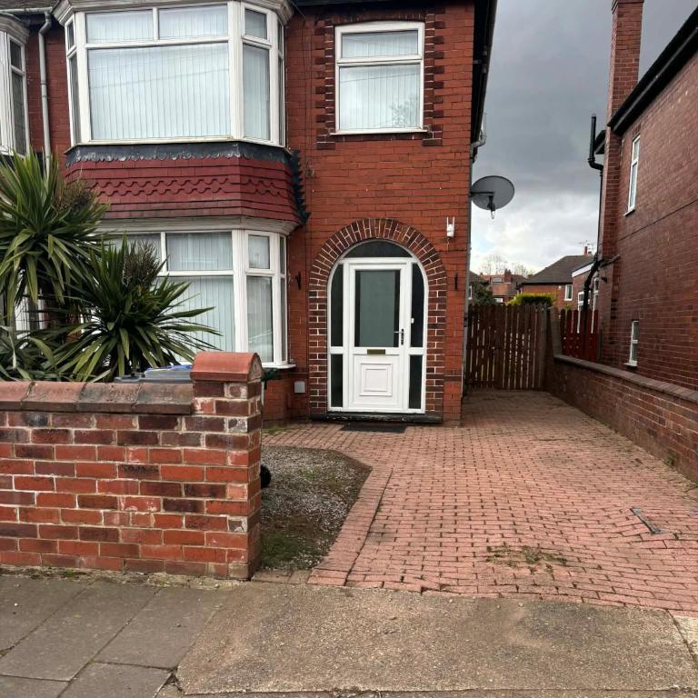 a brick house with a white door and a brick driveway at Cosy 3 Bed house with garden 5 min walk from Doncaster Racecourse in Doncaster