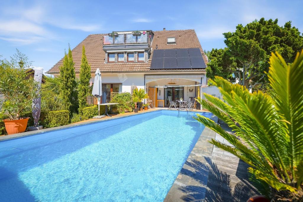 a house with a swimming pool in front of a house at Pension Haus Elmar in Rösrath