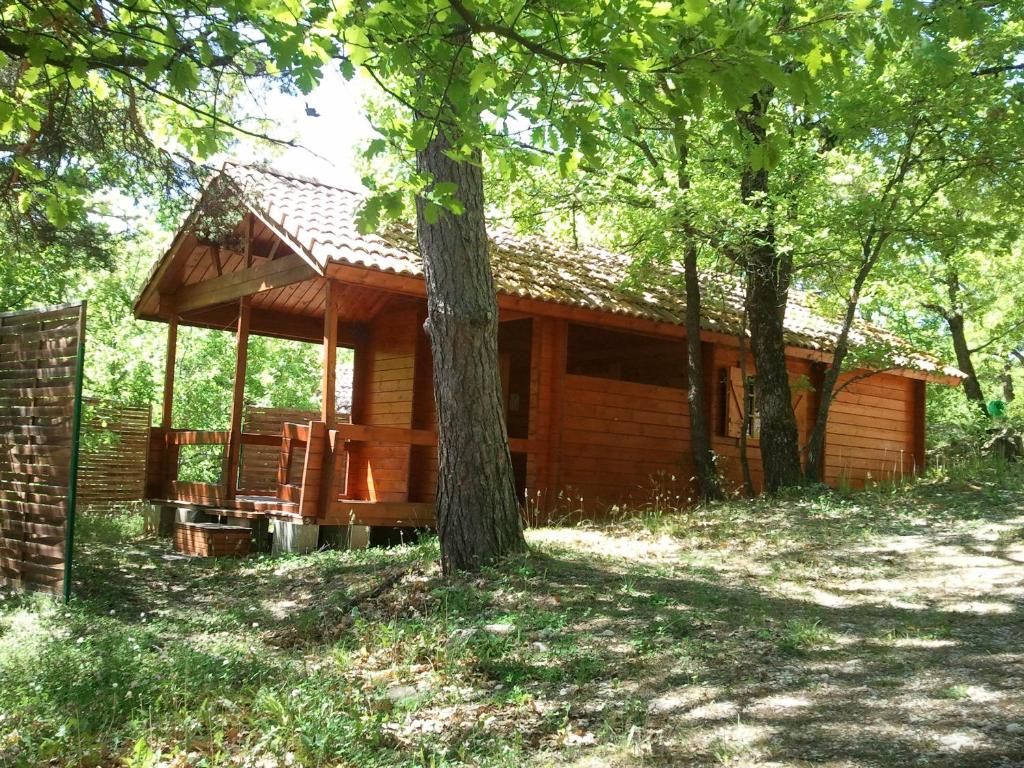 a log cabin in the woods with a tree at Saut du moine in Simiane-la-Rotonde