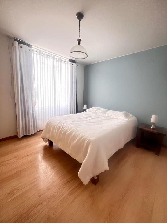a bedroom with a large bed with a white blanket at Subvolcanic Point in Arequipa