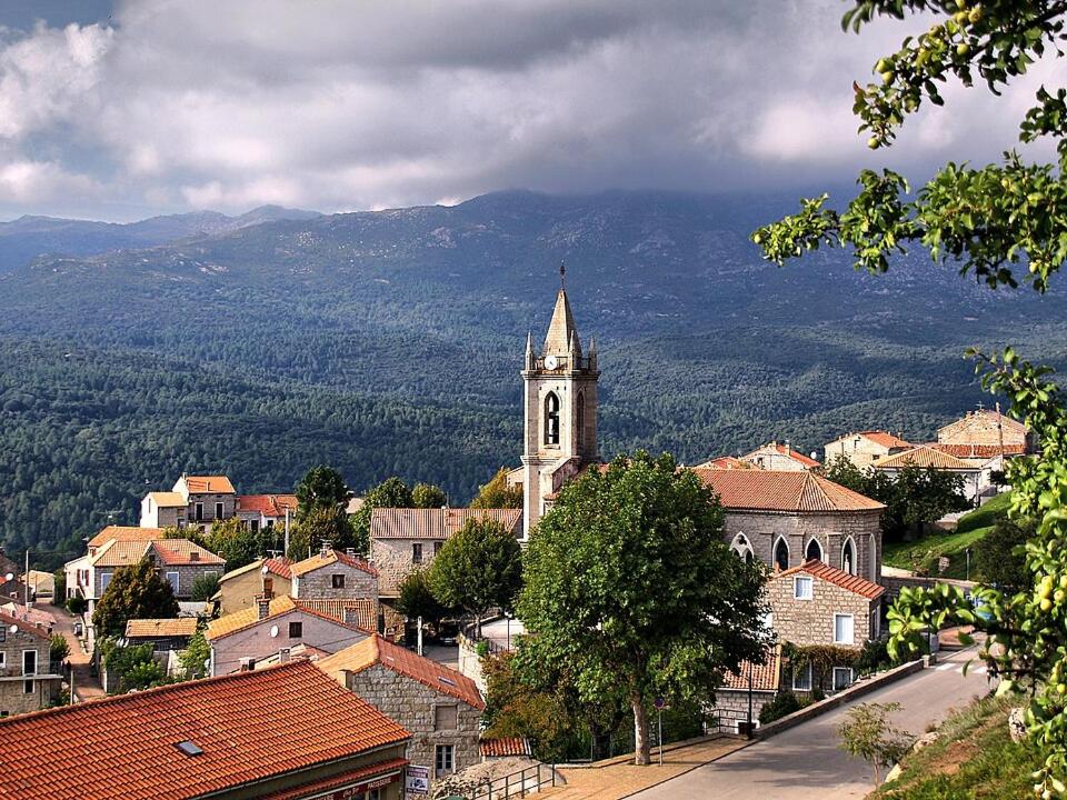 a view of a town with a clock tower at a casetta di a Faragina in Zonza
