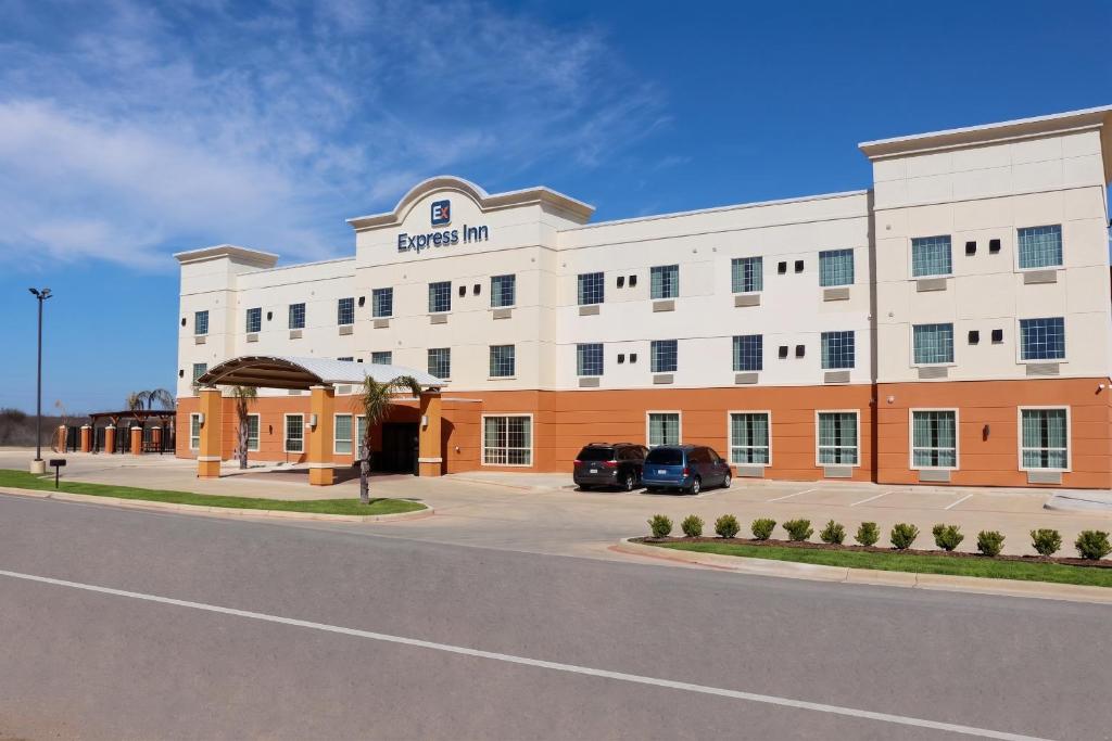 a front view of a hotel with a parking lot at Cotulla Express Inn in Cotulla