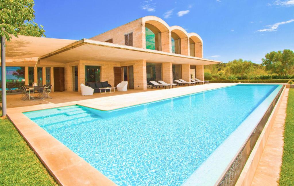 a home with a swimming pool in front of a house at Los Arcos in Felanitx