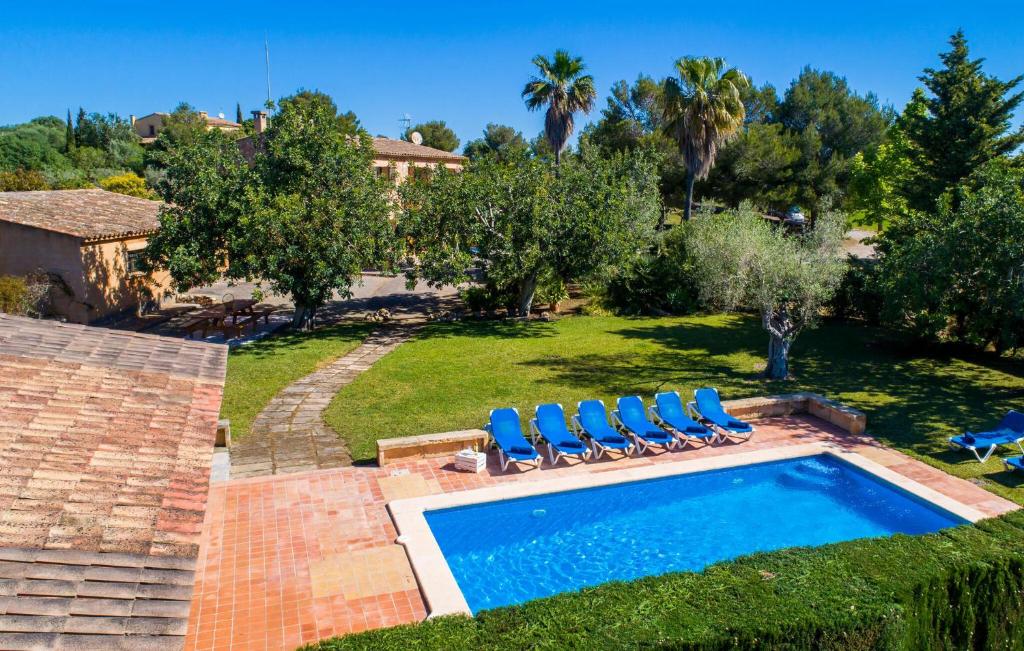 a yard with a swimming pool with blue lounge chairs at Can Moleta in Cala Mendia