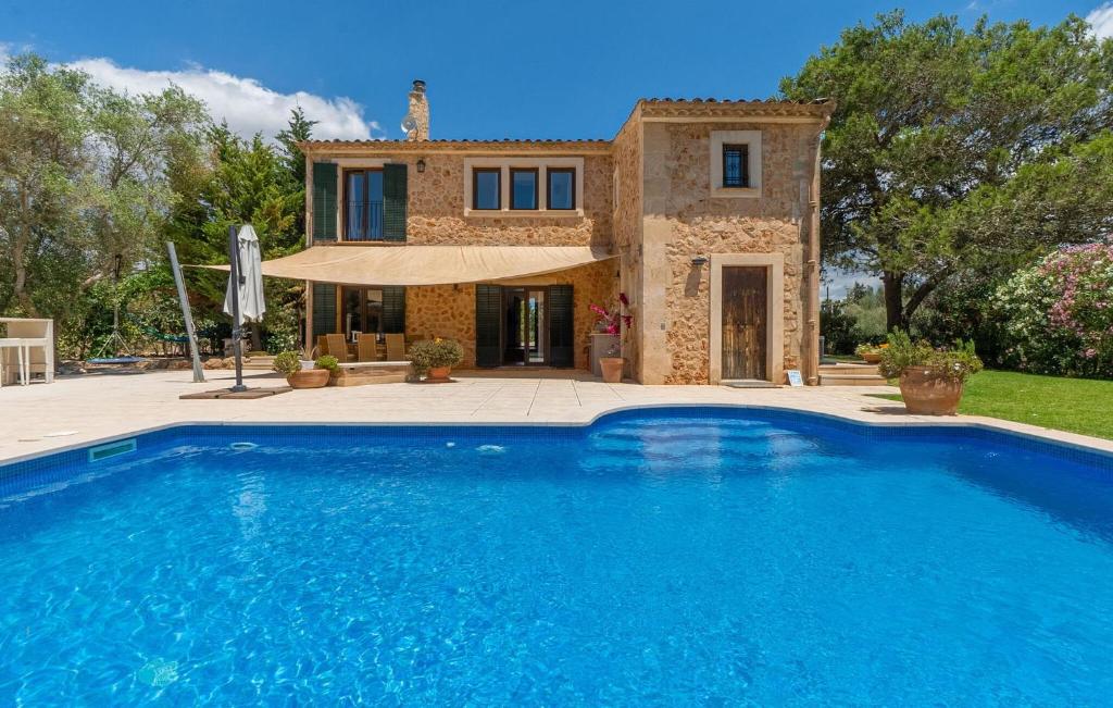 a villa with a swimming pool in front of a house at Kiana in Santa Eugenia