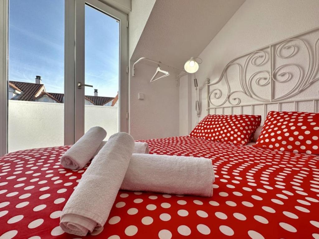 a bedroom with two white towels on a red bed at Duplex primera linea La Arena 4607 in Arnuero