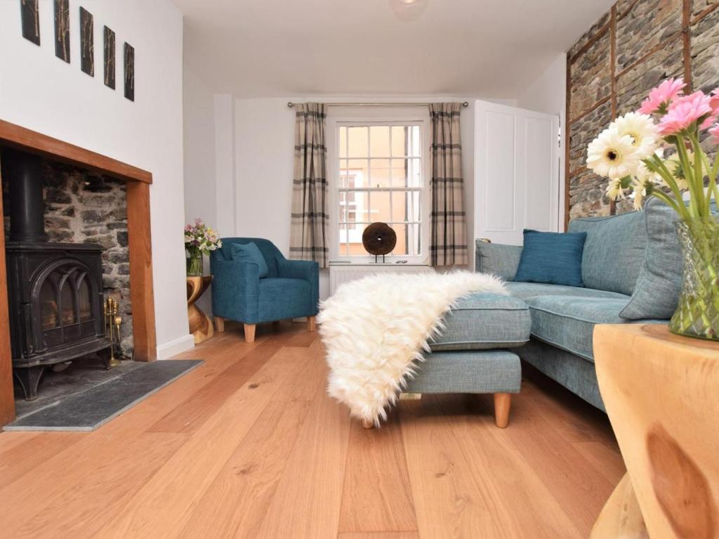a living room with a blue couch and a fireplace at 2 Bed in Bideford oc-75307 in Appledore