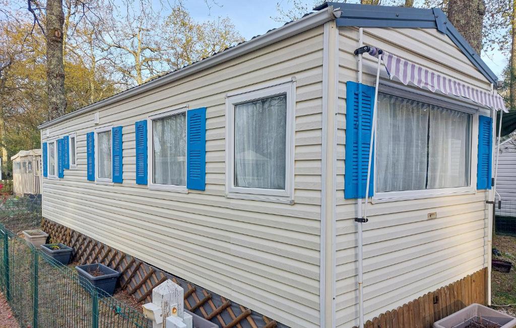 a white and blue house with blue shutters on it at Lovely Stacaravan In La Tremblade in La Tremblade