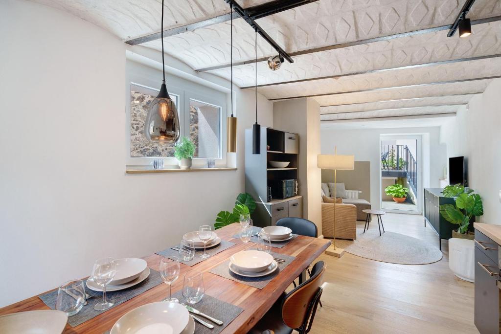 a dining room and living room with a wooden table at Kaisers Anwesen in Vogtsburg