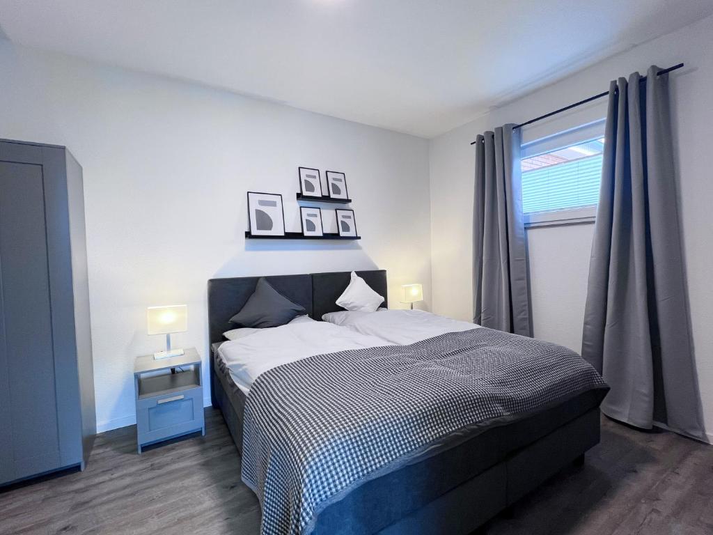 a bedroom with a bed with two pictures on the wall at Emsland-Hus WG2 in Niederlangen