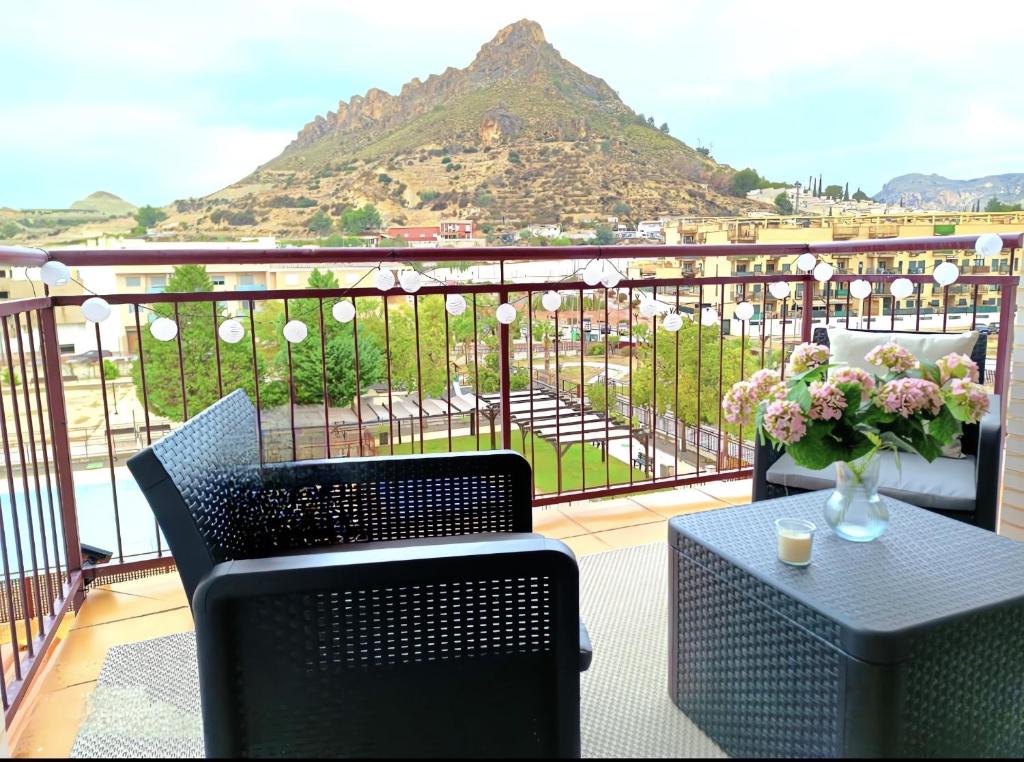 a balcony with two chairs and a table with a vase of flowers at Jazmin ID300 in Villanueva de Río Segura