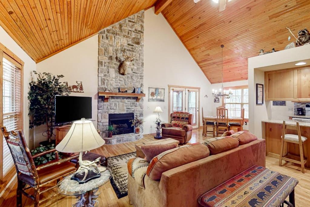 a living room with a couch and a stone fireplace at Lost Creek Haven in Branson West