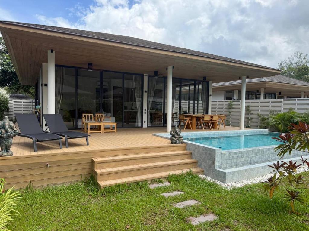 a house with a deck and a swimming pool at MoonLight Villa - 3BR Tropical Pool Retreat in Ko Phangan