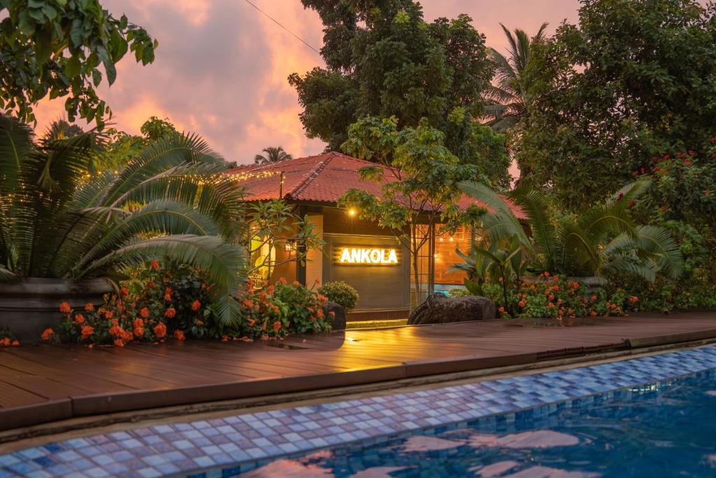 a house with a swimming pool in front of a building at Ankola Hotel in Homagama