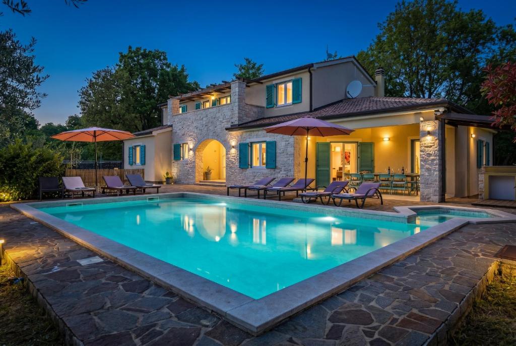 a swimming pool in front of a house at night at Villa Martha in Central Istria with private pool - wellness & table tennis for 12 persons in Žminj