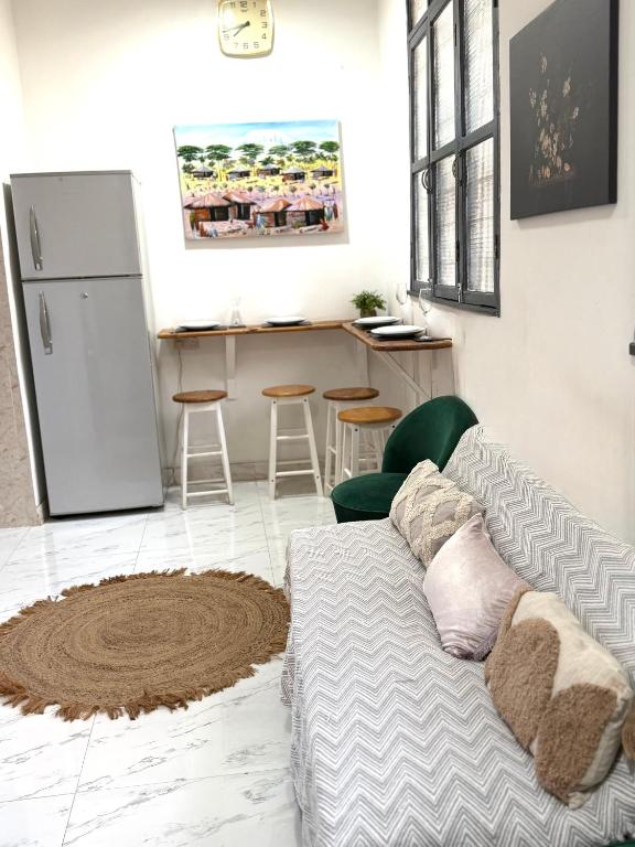 a living room with a couch and a kitchen at The cosy corner in Zanzibar City
