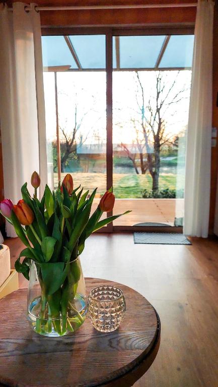 a vase of flowers on a table in a room at CHIC Riverfront Retreat with Private Jacuzzi, BIG BERRY in Gradac