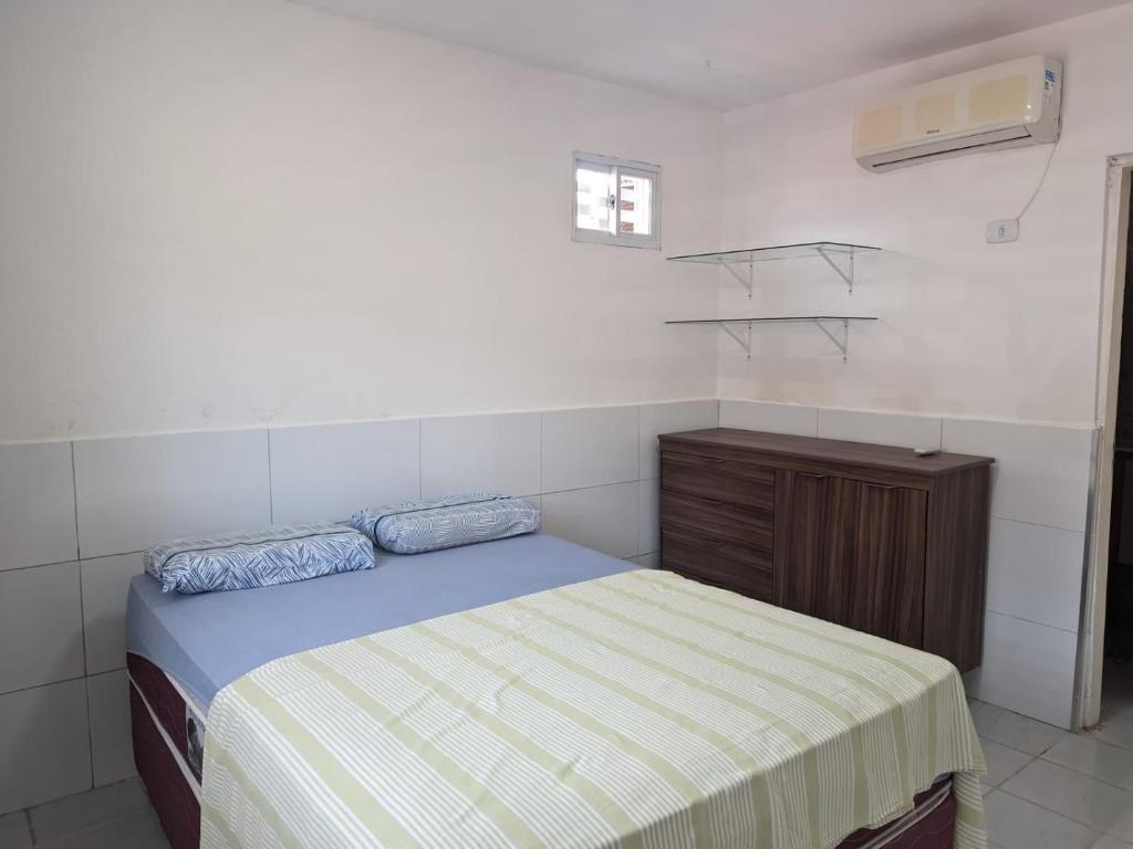 a small bedroom with a bed and a dresser at Well-located house for seasonal rental in Bananeiras. in Bananeiras