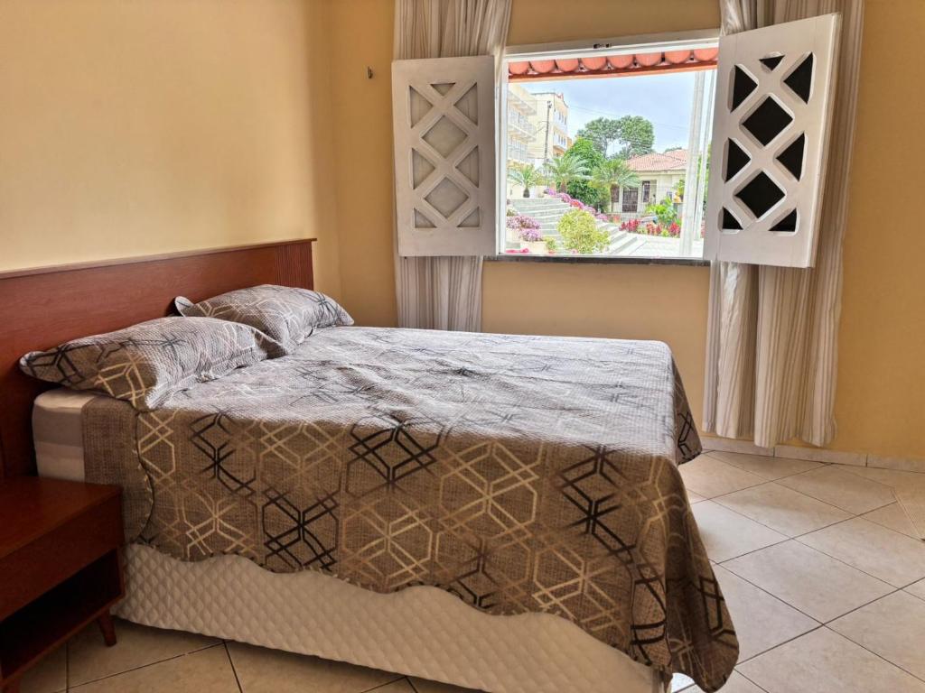 a bedroom with a bed and a window at Casa das Petúnias in Ubajara